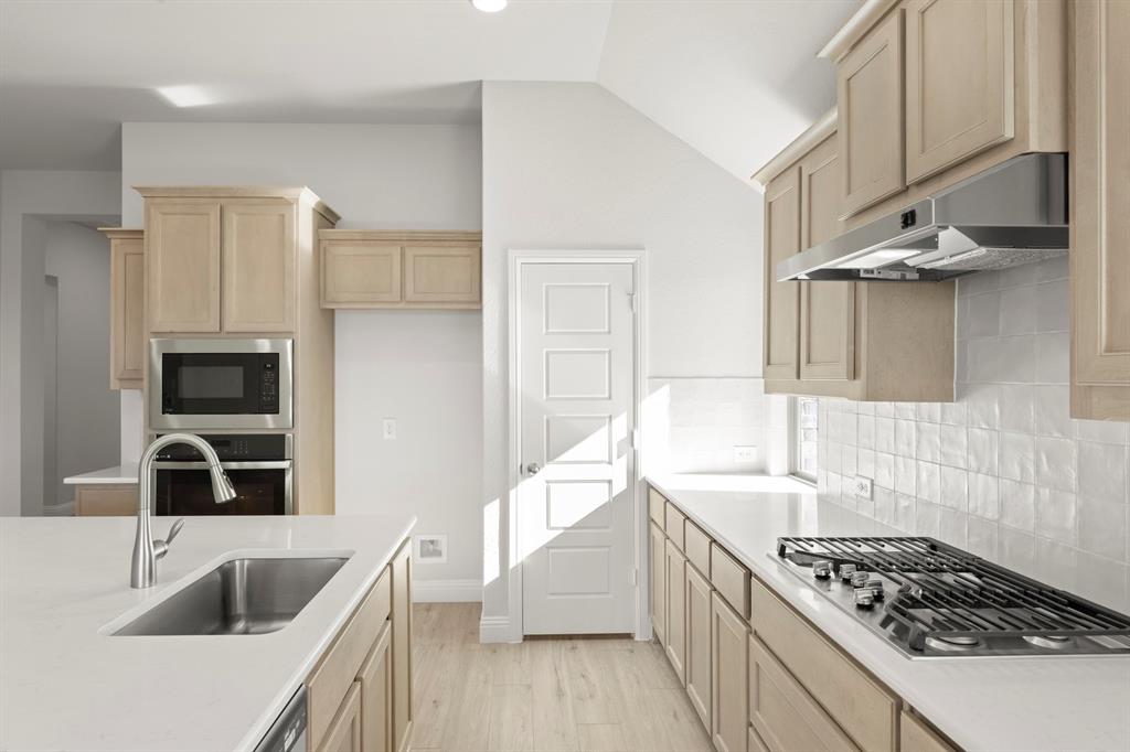 395 Misty Meadow Lane Lavon, TX 75166 - Photo 4 of 24 a kitchen that has a sink and a stove