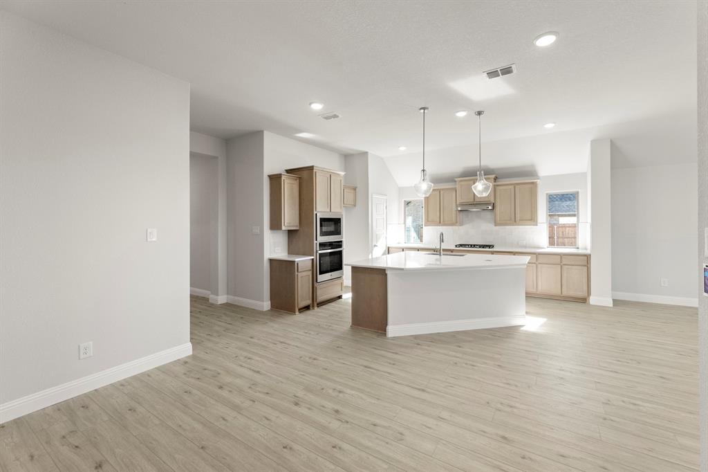 395 Misty Meadow Lane Lavon, TX 75166 - Photo 5 of 24 a large kitchen with a refrigerator and white cabinets