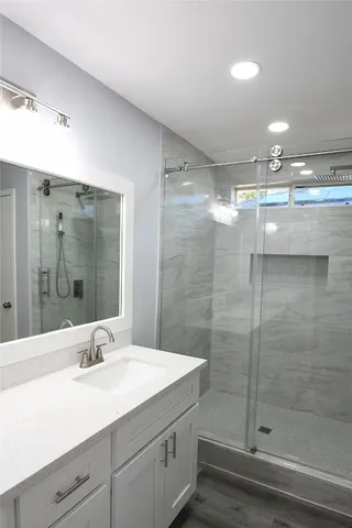 a bathroom with a shower sink and mirror