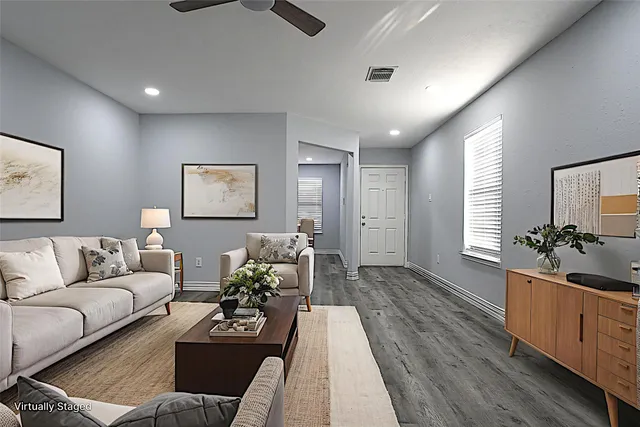 a living room with furniture and a wooden floor