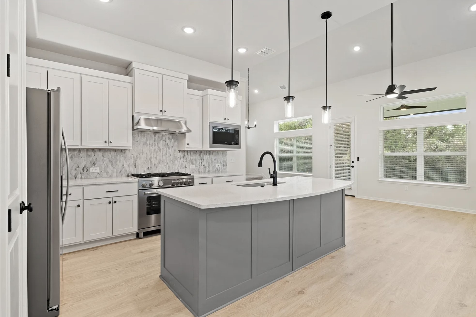 1612 Kit Circle Austin, TX 78758 - Photo 7 of 29 a kitchen with stainless steel appliances granite countertop a sink a stove a refrigerator and white cabinets with wooden floor