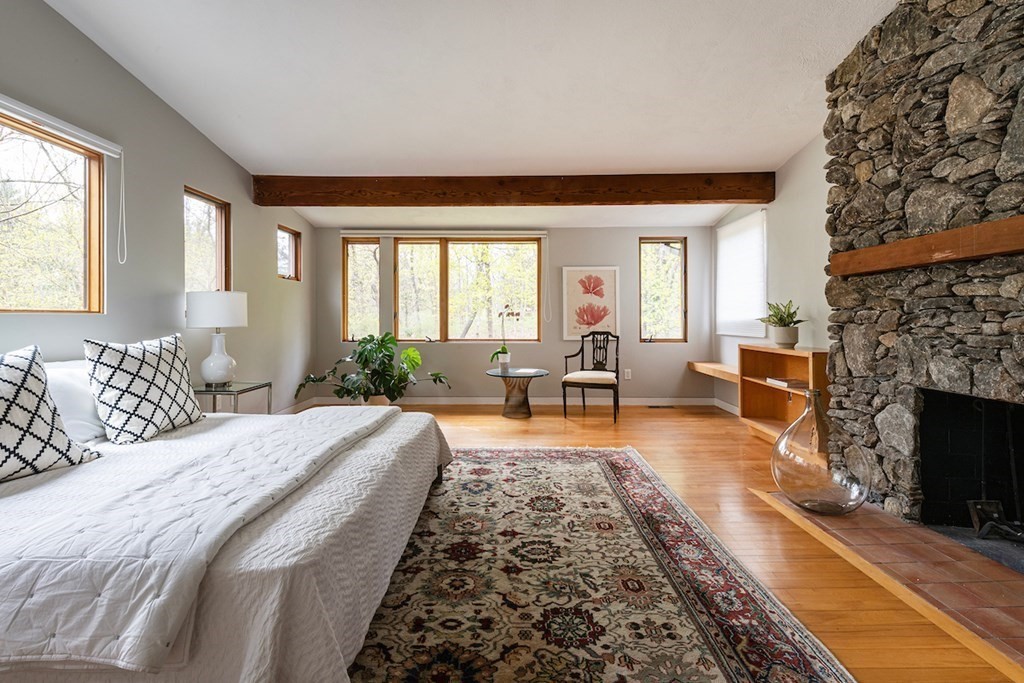 3 Barberry Road Lexington, MA 02421 - Photo 33 of 42 a large bedroom with a large bed a fireplace and windows