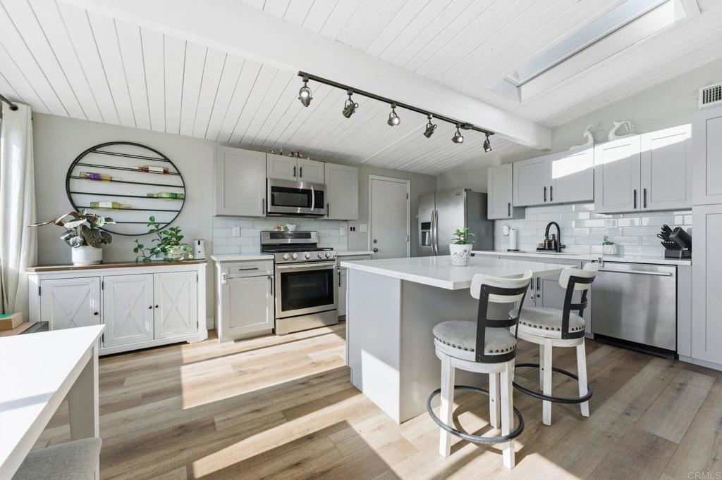 a kitchen with microwave a stove and cabinets