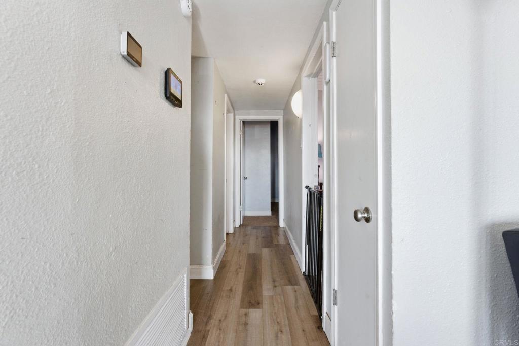 9838 Ivanho Street Spring Valley, CA 91977 - Photo 12 of 25 a view of a hallway with wooden floor and a bathroom
