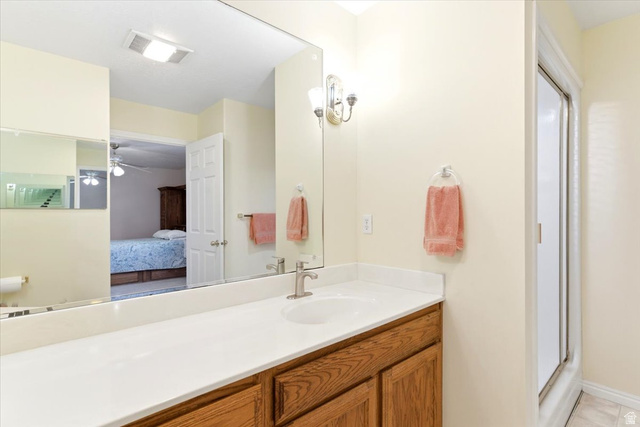 72 Canal Bank Road Garland, UT 84312 - Photo 16 of 40 Bathroom vanity featuring a single sink, light-toned countertop, wood-finish cabinetry, and an overhead sconce light fixture