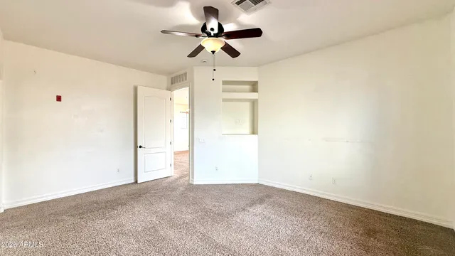 en empty room with a ceiling fan and a window