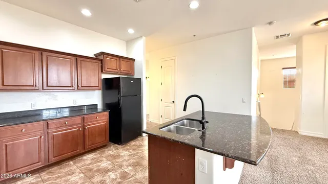 a kitchen with granite countertop a kitchen island a sink cabinets and stainless steel appliances