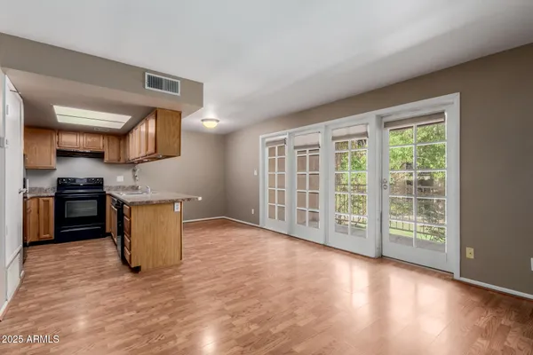 a view of kitchen with stainless steel appliances granite countertop a stove top oven a sink and a granite counter tops with wooden floors