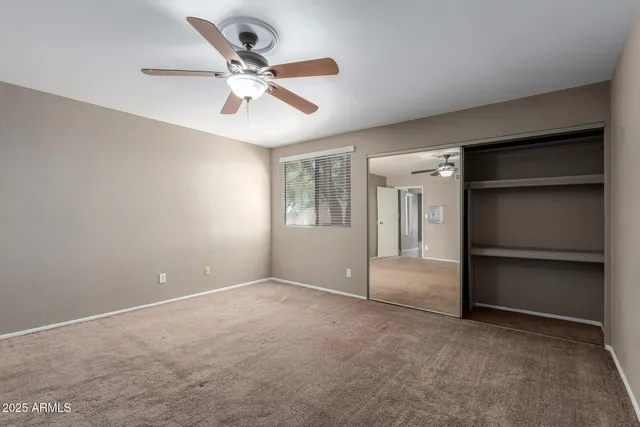 a view of an empty room with a ceiling fan