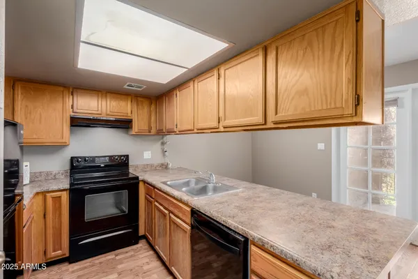 a kitchen with granite countertop cabinets stainless steel appliances and a window