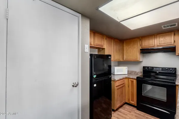 a kitchen with a refrigerator and a stove top oven