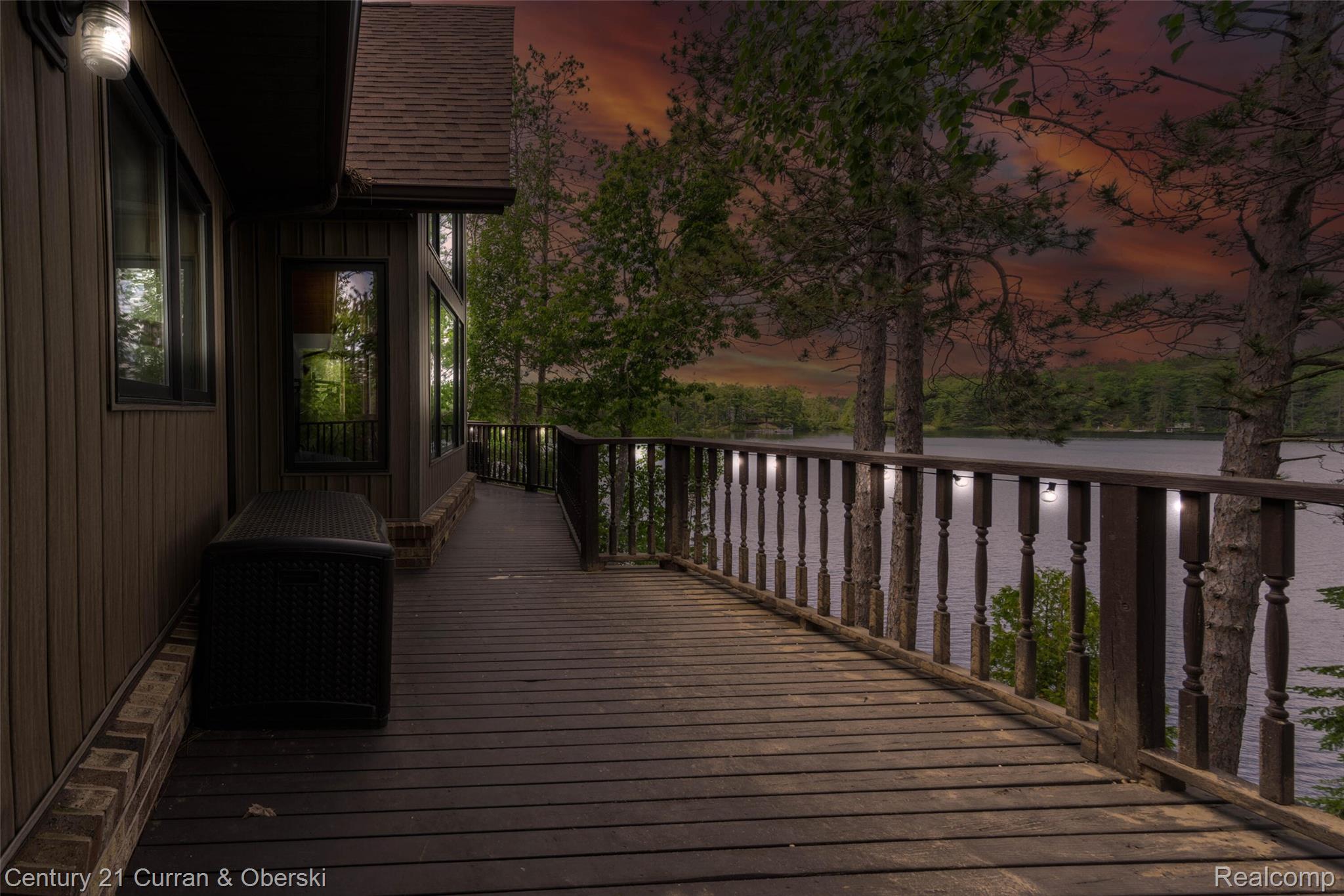 8775 Winding Rdg Drive Millersburg, MI 49759 - Photo 36 of 53 Expansive wood deck with baluster railing, integrated lighting, and panoramic water scenery