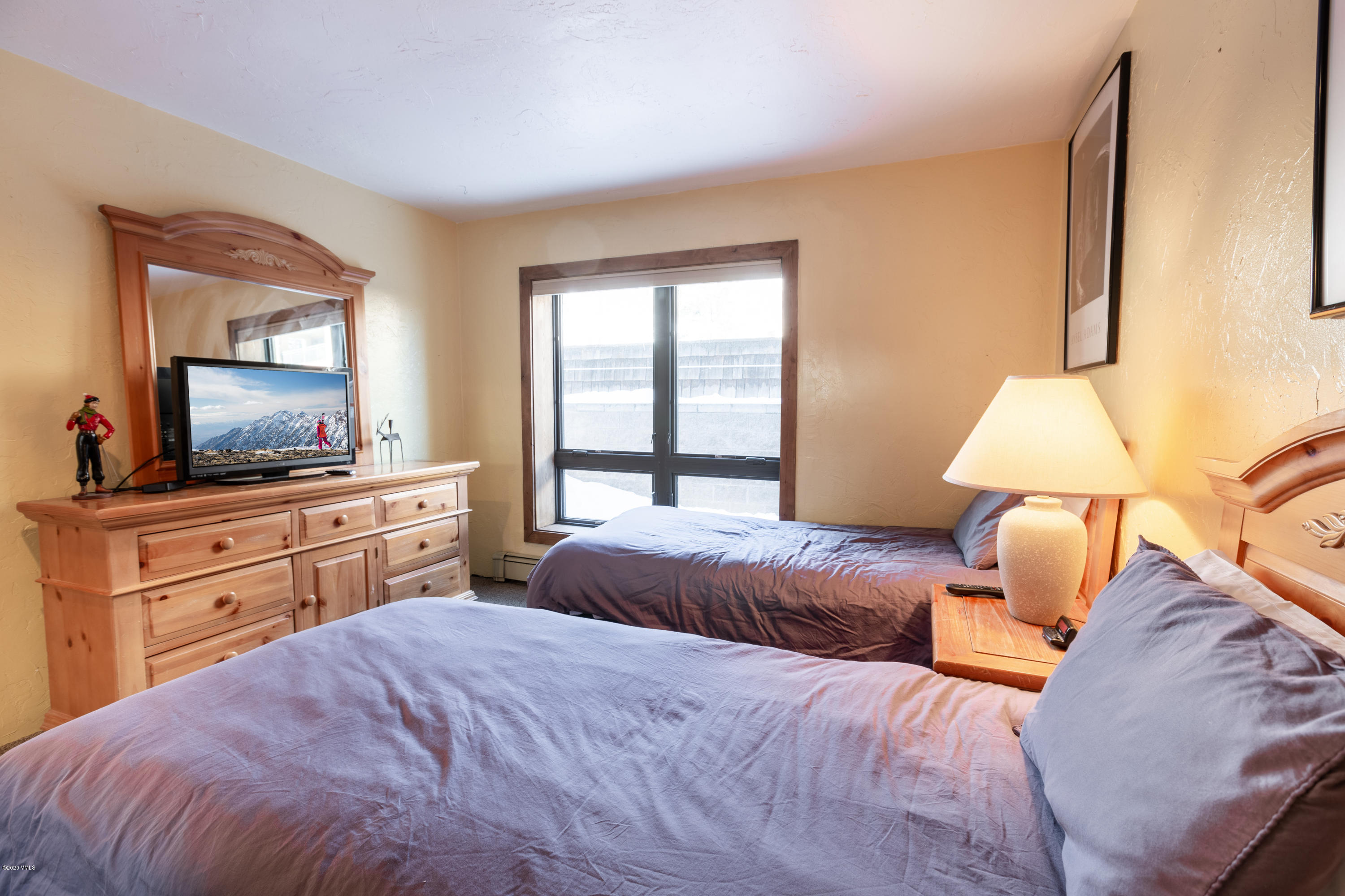 963 Lions Ridge Loop, Unit 501 Vail, CO 81657 - Photo 7 of 9 a bedroom with a large bed and a flat tv screen on dresser