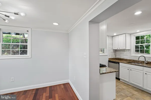 a kitchen with granite countertop white cabinets and a window