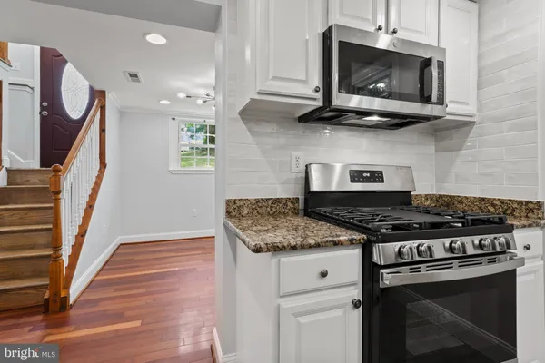 a kitchen with stainless steel appliances granite countertop a refrigerator and a sink