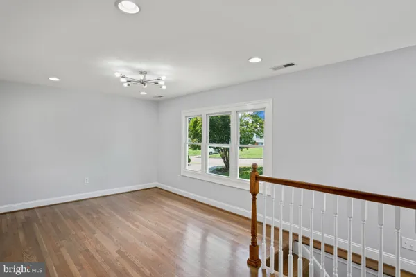a view of a room with wooden floor and windows