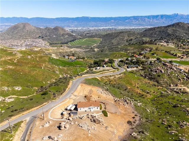 an aerial view of a house with a mountain