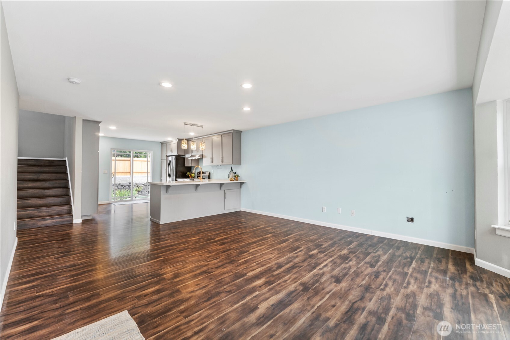 1211 Maybelle Street Sumner, WA 98390 - Photo 8 of 38 a view of empty room with wooden floor and kitchen view