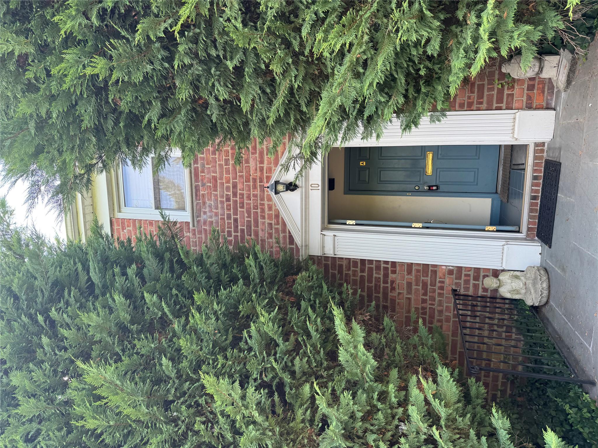 a front view of a house with a tree