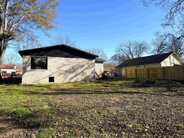 a view of a wooden house with a yard