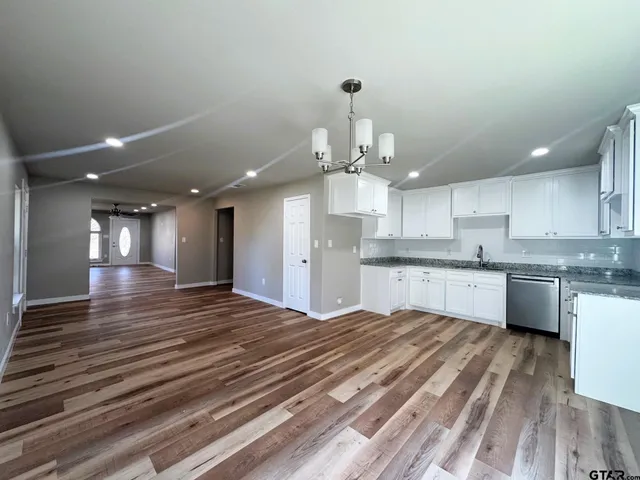 a large kitchen with kitchen island a sink stainless steel appliances and cabinets