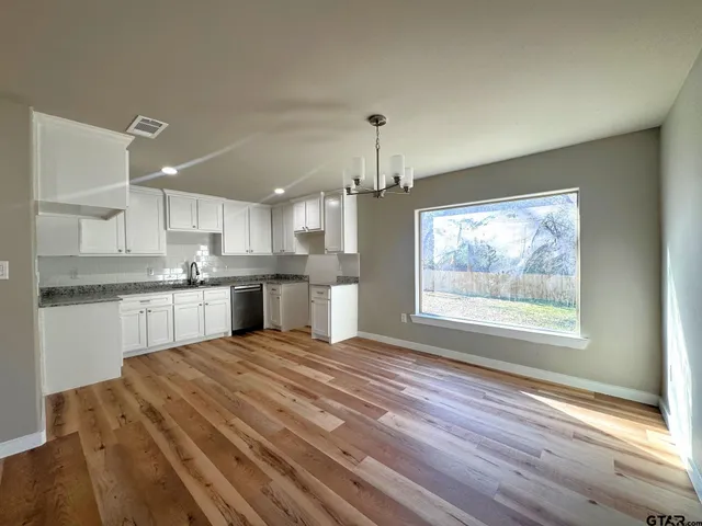 a large kitchen with kitchen island a sink stainless steel appliances and cabinets