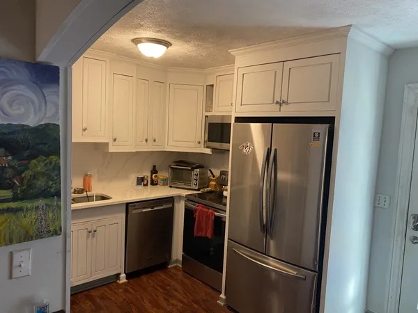a kitchen with stainless steel appliances a refrigerator sink and cabinets