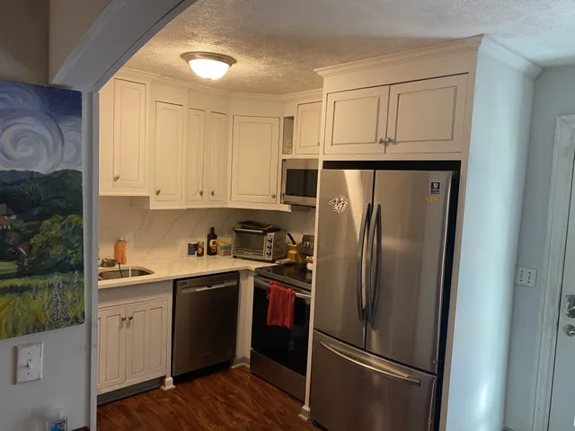 a kitchen with stainless steel appliances a refrigerator sink and cabinets