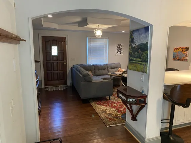 a living room with furniture and a hard wood floor
