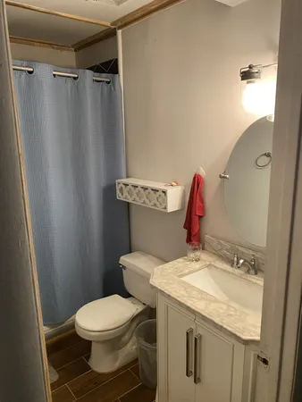 a bathroom with a granite countertop toilet sink and shower