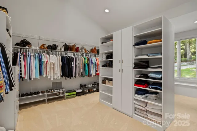 a view of walk in closet with clothes and shoes