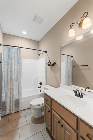 a bathroom with a granite countertop sink a toilet and shower