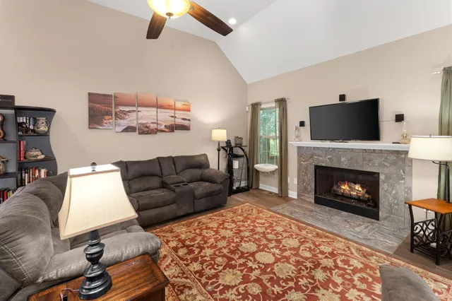 a living room with furniture a flat screen tv and a fireplace