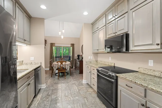 a kitchen with stainless steel appliances granite countertop a stove a sink and a microwave