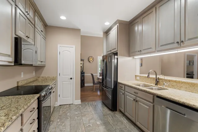 a kitchen with stainless steel appliances granite countertop a sink stove and refrigerator