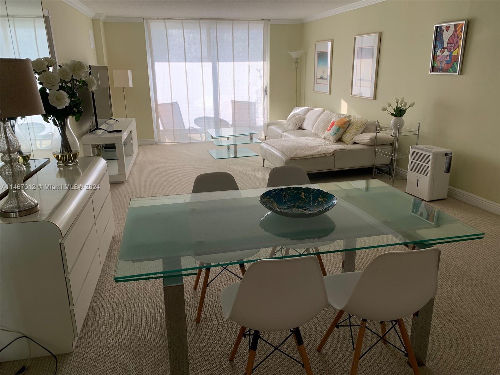 6039 Collins Avenue, Unit 1630 Miami Beach, FL 33140 - Photo 16 of 37 a living room with furniture and a table