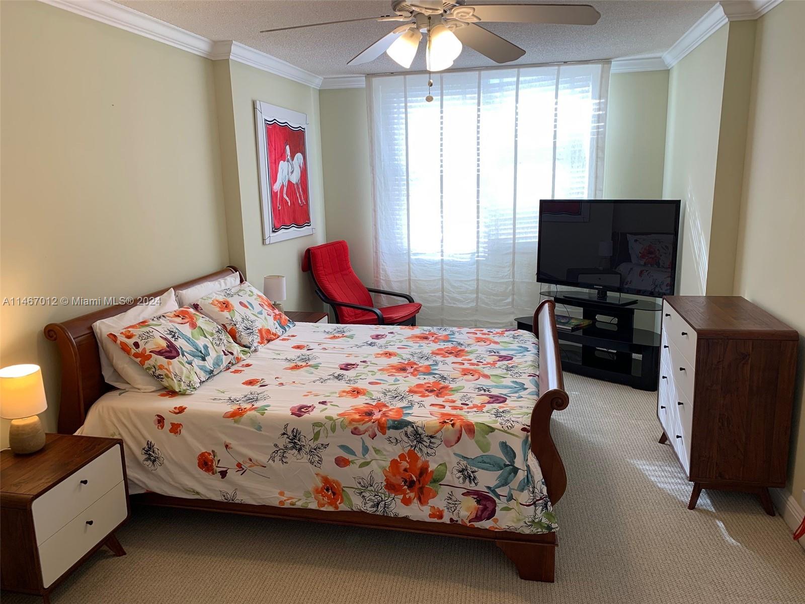 6039 Collins Avenue, Unit 1630 Miami Beach, FL 33140 - Photo 4 of 37 a bedroom with a bed and a flat screen tv