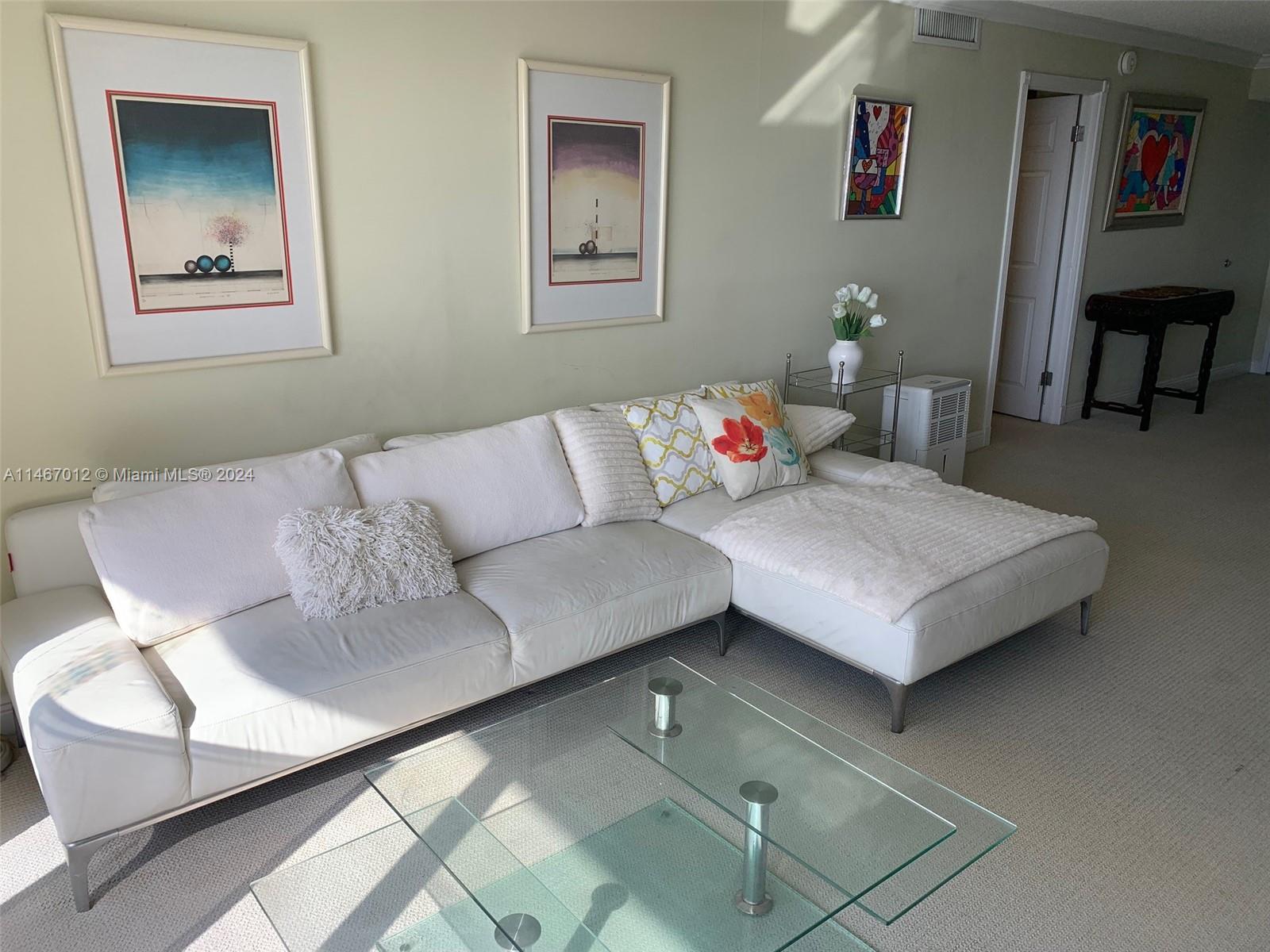 6039 Collins Avenue, Unit 1630 Miami Beach, FL 33140 - Photo 7 of 37 a living room with furniture and a table