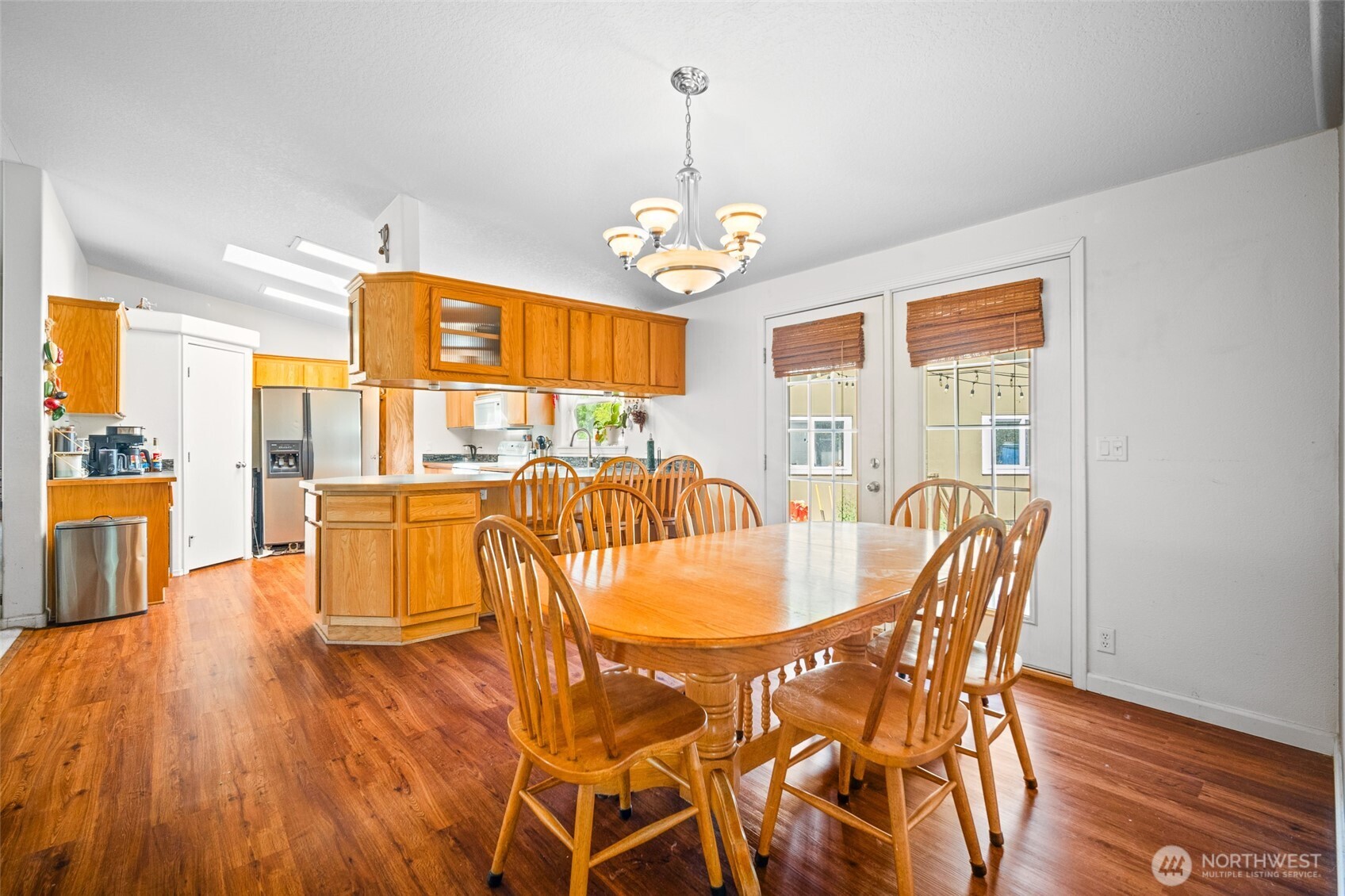 4230 Cody Road Blaine, WA 98230 - Photo 17 of 38 a dining room with wooden floor a chandelier a wooden table and chairs