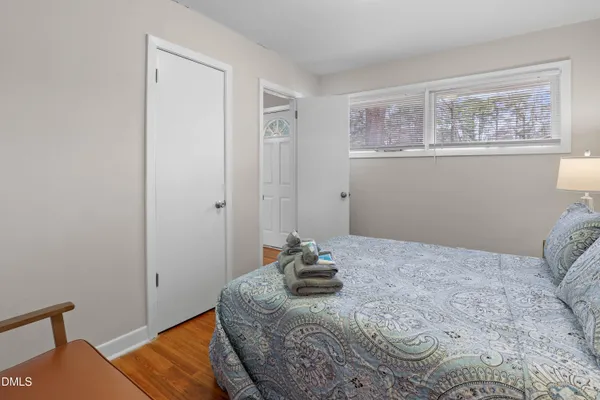 a bedroom with a bed and wooden floor