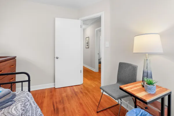 a bedroom with a bed and a lamp with wooden floor
