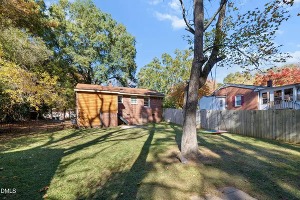 a view of a house with backyard and a tree