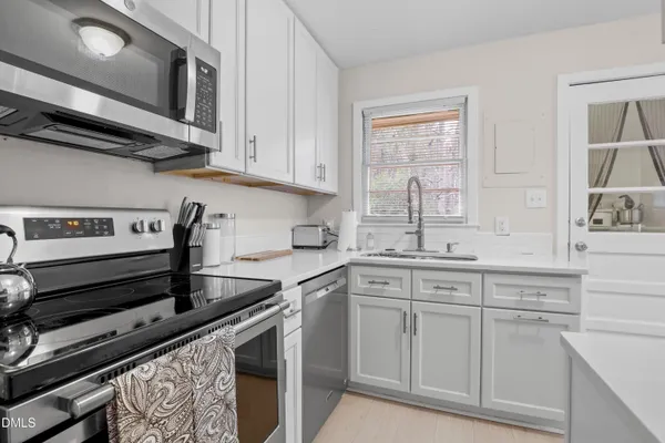 a kitchen with appliances a refrigerator and cabinets