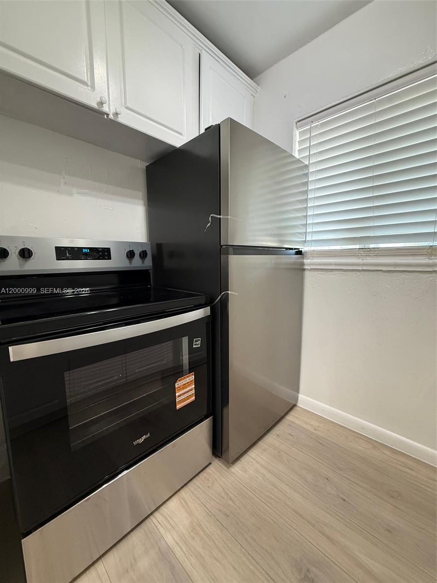 10 Northwest 77th Street, Unit 8 Miami, FL 33150 - Photo 1 of 15 a kitchen with granite countertop a stove and a refrigerator