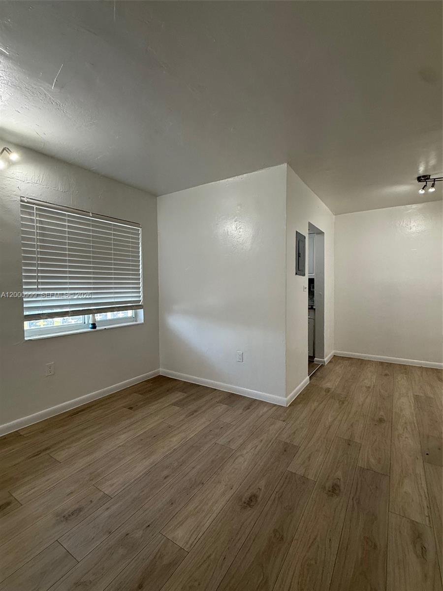 10 Northwest 77th Street, Unit 8 Miami, FL 33150 - Photo 12 of 15 a view of an empty room with wooden floor and a window