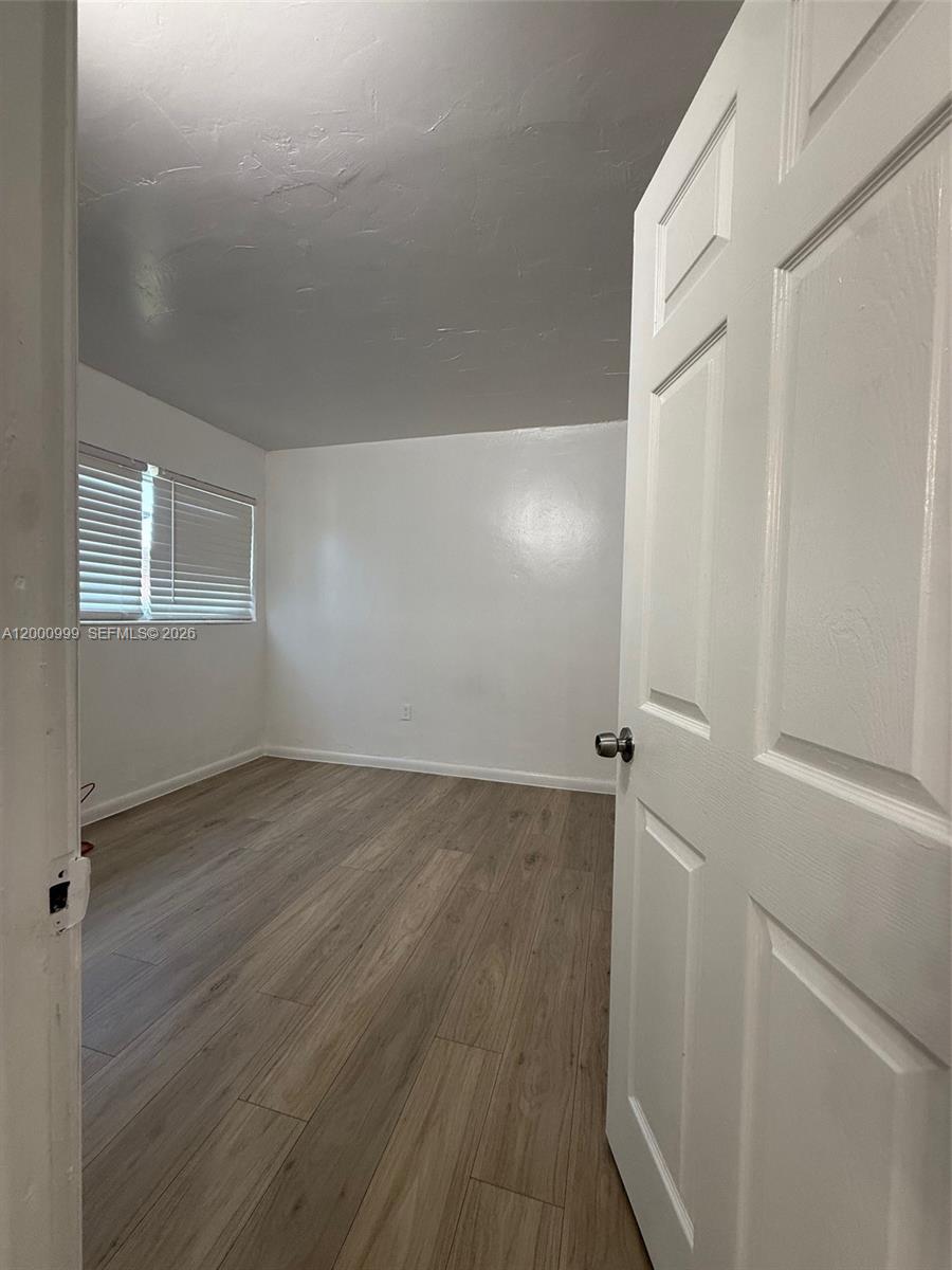 10 Northwest 77th Street, Unit 8 Miami, FL 33150 - Photo 7 of 15 an empty room with wooden floor and windows