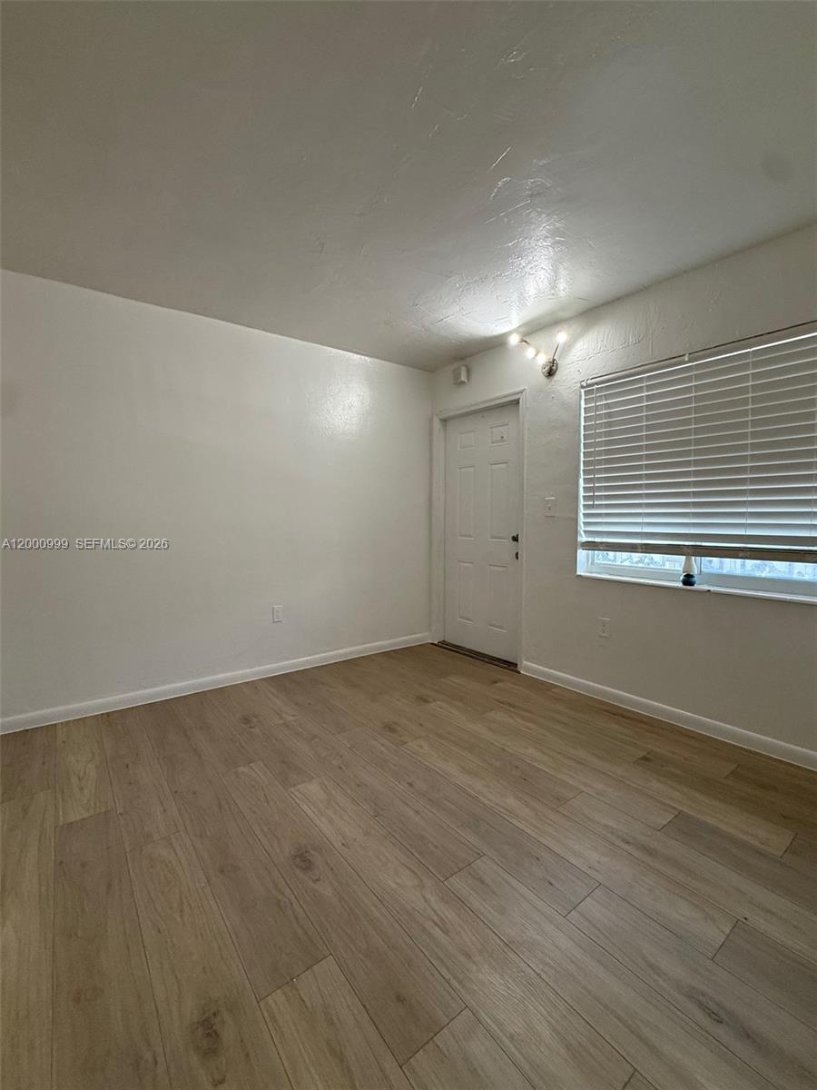 10 Northwest 77th Street, Unit 8 Miami, FL 33150 - Photo 10 of 15 an empty room with wooden floor and windows