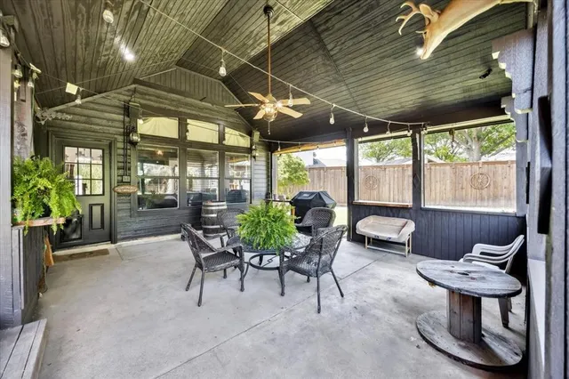 a view of a patio with a table and chairs and a barbeque