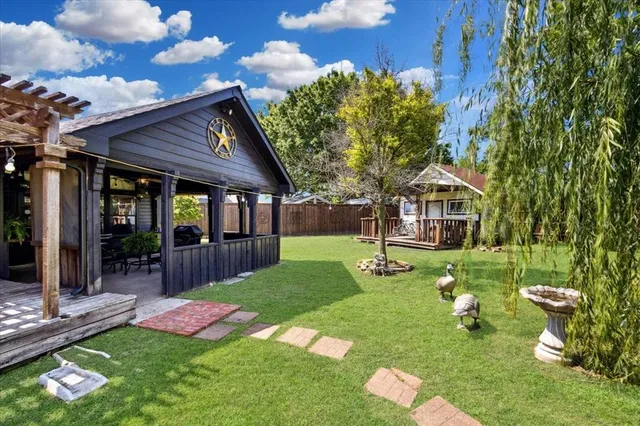 a view of backyard with table and chairs and potted plants