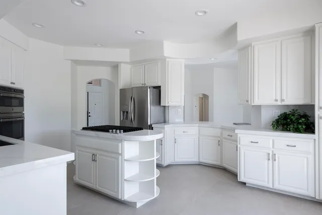 a kitchen with white cabinets and stainless steel appliances